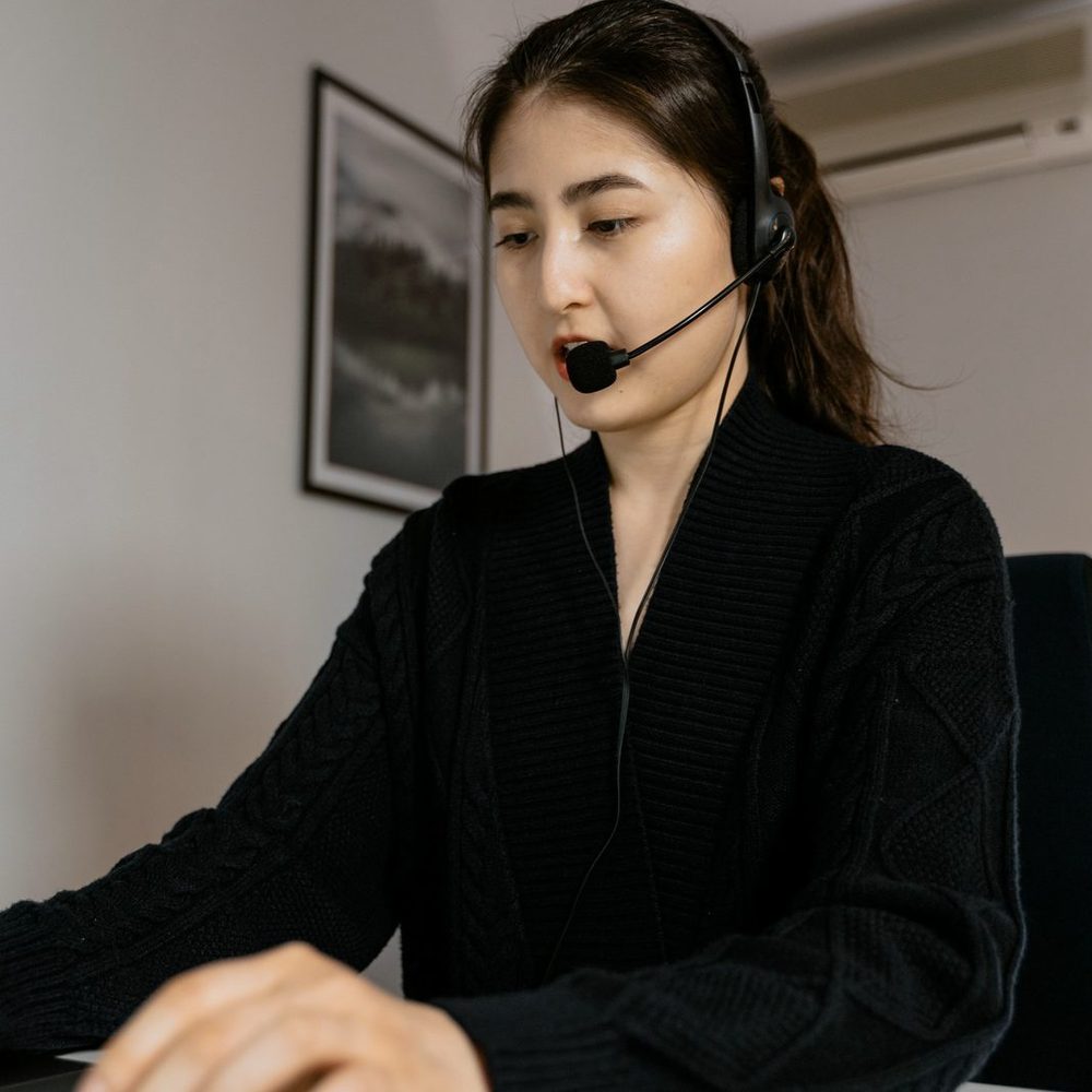 Un'operatrice con la cuffia parla con un cliente davanti al computer