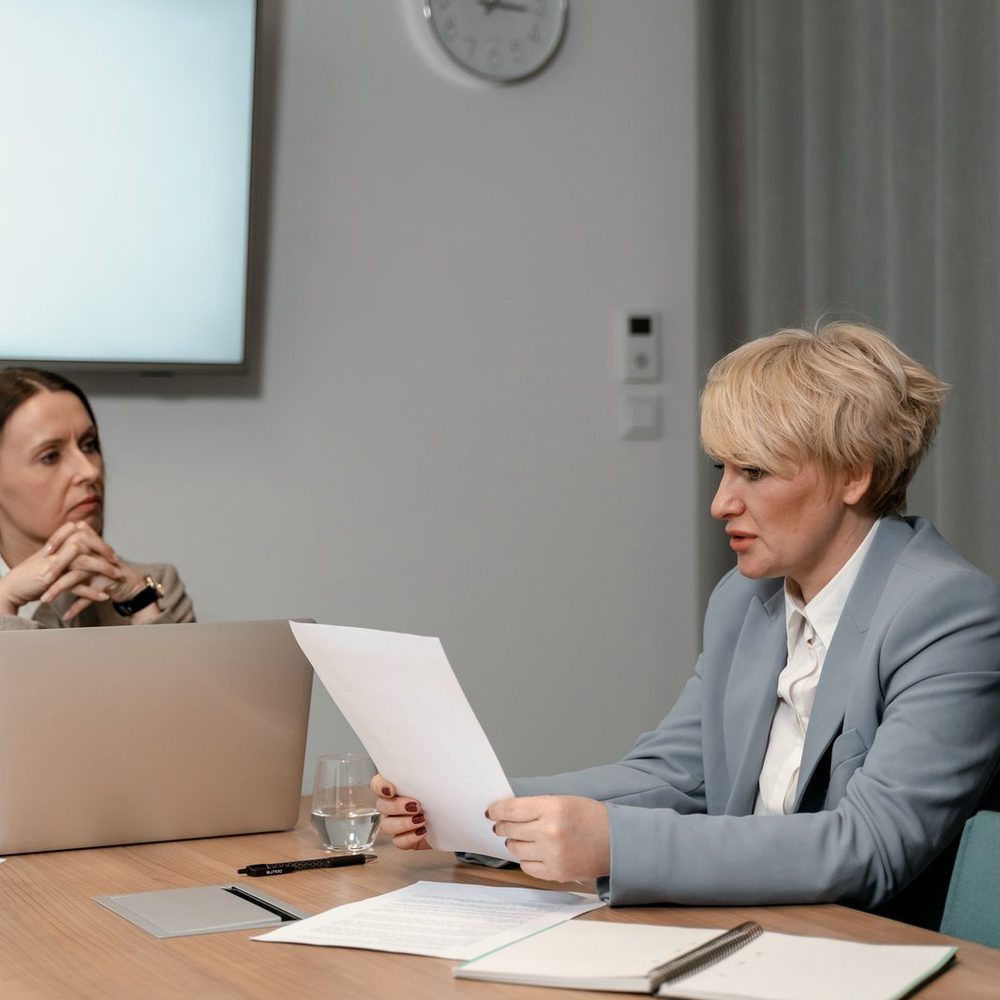 Una responsabile parla con una collaboratrice in un colloquio a due, al tavolo di una sala riunioni
